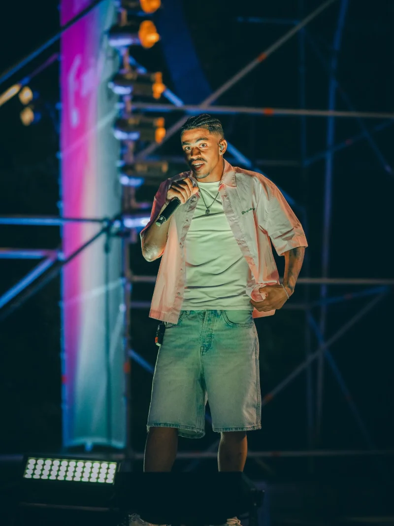 Tungono a cantar de frente para o público, palco nocturno